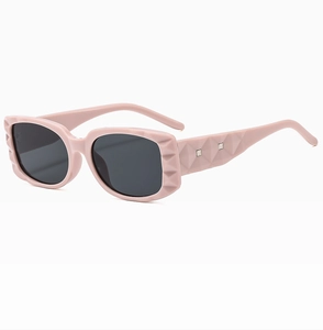 Detail view of pink square sunglasses featuring a geometric diamond texture on the temples