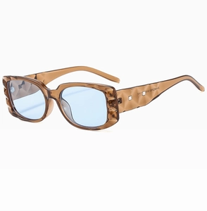 Detail of square sunglasses with brown lattice texture frame and light blue lenses