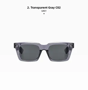 Detail of square transparent grey sunglasses featuring iconic golden metal T-hinge logo