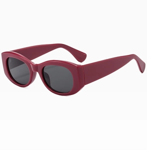 Close-up of vintage burgundy oval sunglasses with wide temples and dark lenses
