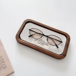 Détail de lunettes de soleil ovales enfant sur plateau en noyer, style vintage