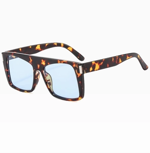 Detail view of tortoiseshell square sunglasses frame with silver metal accents and blue lenses