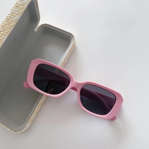 Pink matte kids polarized sunglasses with dark lenses and cream textured flip-top case