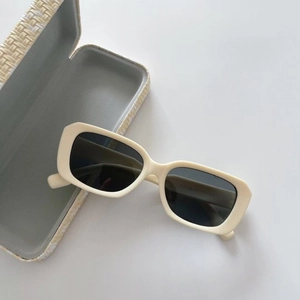 Detail of cream matte polarized kids sunglasses with a woven texture protective case