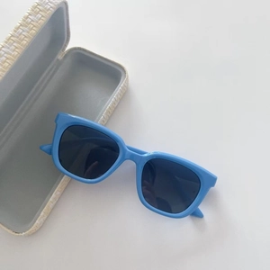 Dettaglio degli occhiali da sole blu per bambini con custodia a trama intrecciata