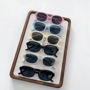 Set of 6 colorful silicone polarized sunglasses for kids with oval frames on wooden tray