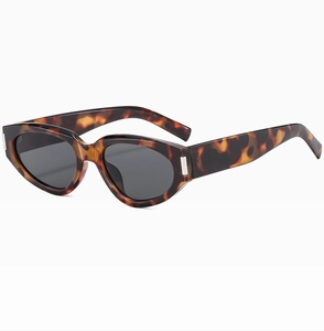 Detail of tortoise shell cat eye sunglasses featuring silver metal hinge accents