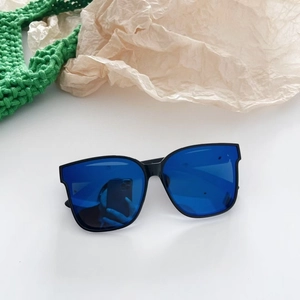 Detail einer quadratischen schwarzen Sonnenbrille mit blau verspiegelten Gläsern auf Weiß