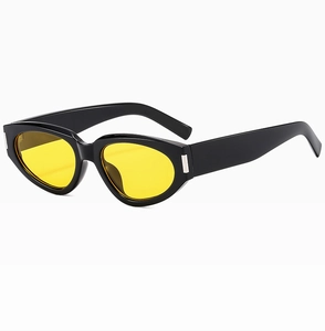 Close-up of retro cat-eye sunglasses with thick black frames and yellow tinted lenses