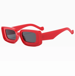 Vue détaillée des lunettes de soleil rectangulaires rouges à monture épaisse et verres gris
