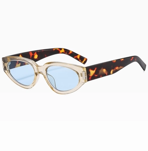 Detail of cat eye sunglasses with blue lenses and tortoise pattern temple arms