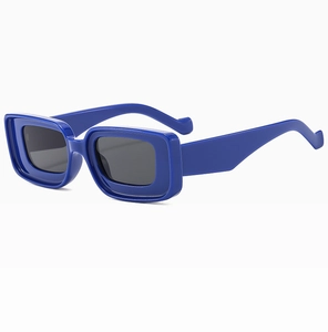 Détail de lunettes de soleil rectangulaires bleu klein avec monture épaisse et verres gris