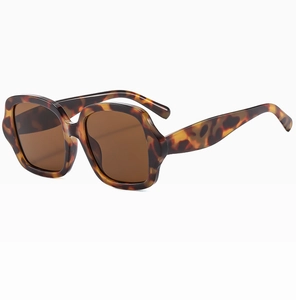 Détail de lunettes de soleil carrées oversize en écaille avec des verres marron vintage