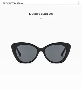 Close-up of sleek glossy black cat-eye sunglasses with dark grey lenses in a flat lay view