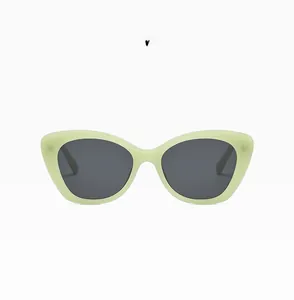 Detailed close-up of jelly green cat-eye sunglasses frames with dark grey lenses