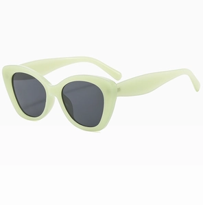 Detail view of mint green cat eye sunglasses with dark lenses from a 45-degree angle
