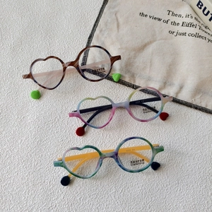 Close-up of asymmetrical heart and round kids blue light blocking glasses on canvas