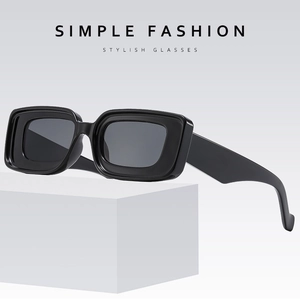 Lunettes de soleil rectangulaires à monture épaisse noire sur présentoir minimaliste