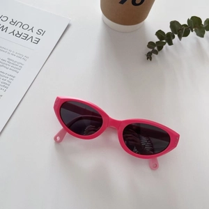 Nahaufnahme der rosa Katzenaugen-Kindersonnenbrille mit dunklen Gläsern auf weißem Grund