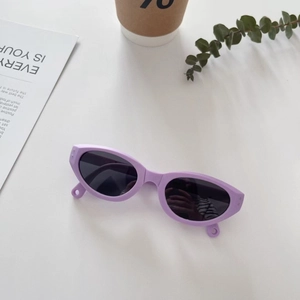 Detailaufnahme der faltbaren lila Kinder-Sonnenbrille mit retro ovalen Gläsern auf Tisch