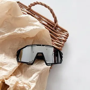 Detail view of large frame kids sports goggles with white splatter pattern on black frame