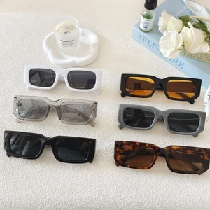Retro rectangle sunglasses in six trendy colors displayed with minimalist decor