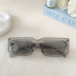 Detail of transparent grey rectangular sunglasses on an elegant textured background