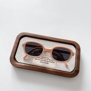 Detail of folding children sunglasses featuring a beige frame and dark polarized lenses