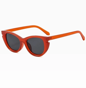 Close-up of bright orange translucent cat-eye sunglasses with dark gray polarized lenses