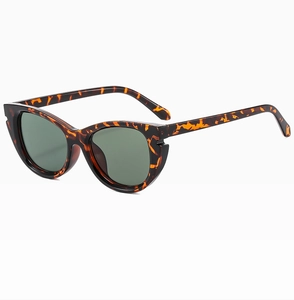 Detailed view of retro cat-eye sunglasses featuring tortoiseshell frames and dark green lenses