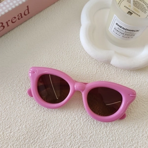 Détail de lunettes de soleil œil-de-chat roses pour enfants avec monture en résine