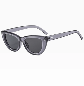 Detail of translucent grey cat-eye sunglasses with silver metal rivets and grey lenses