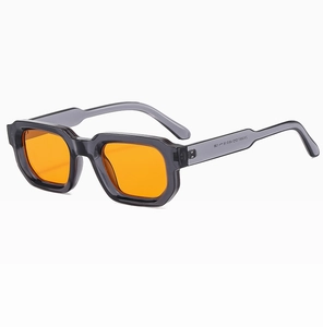 Detailed view of square sunglasses with grey transparent frame and bright orange lenses