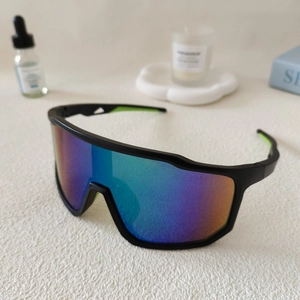Detail von mattschwarzer Radsportbrille mit bunten Verlaufsgläsern und neongrünen Akzenten