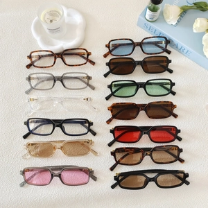 Collection de lunettes de soleil rectangulaires rétro de couleurs sur table blanche