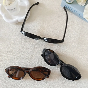 Lot de lunettes de soleil œil-de-chat ovales rétro noir et écaille sur bureau texturé