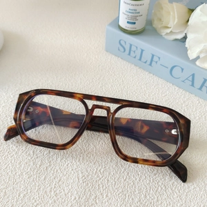 Gros plan de lunettes de soleil carrées à double pont en écaille au style vintage chic