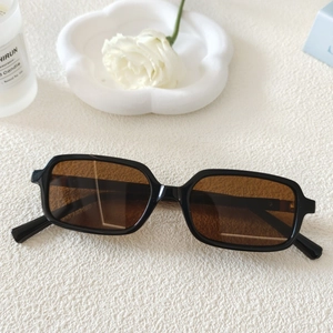 Détail de lunettes de soleil vintage carrées avec monture noire et verres marron