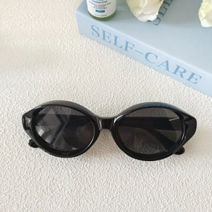 Lunettes de soleil œil-de-chat ovales rétro avec monture noire brillante et verres noirs