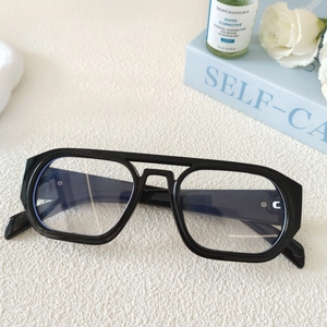 Gros plan détaillé de lunettes aviateur noires rétro à double pont sur une surface blanche