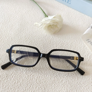 Gros plan de lunettes de soleil rectangulaires noires avec détail de charnière dorée chic