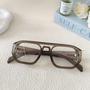 Détail de lunettes aviateur carrées avec monture grise transparente sur fond blanc