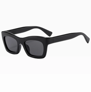Détail de lunettes de soleil noires carrées polies avec verres foncés sur fond blanc