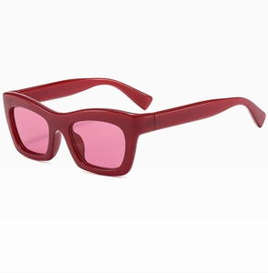 Gros plan sur les lunettes de soleil œil-de-chat avec monture rouge et verres roses