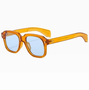 Dettaglio occhiali da sole vintage con montatura ambra quadrata e lenti blu e marcatura