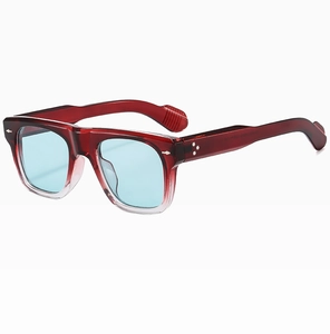 Dettaglio macro della montura in acetato bordeaux con rivetti a freccia e lenti blu