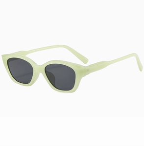 Detail view of mint green cat-eye sunglasses with dark grey lenses and broad frame
