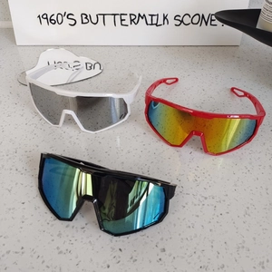 Close-up of three aerodynamic kids' sports sunglasses with colorful mirrored lenses