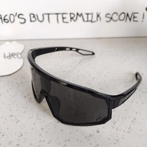 Close-up of matte black sports sunglasses with wide panoramic lens and hollowed-out arms