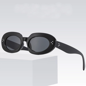 Retro oval black sunglasses with silver rivets and grey lenses on white pedestal
